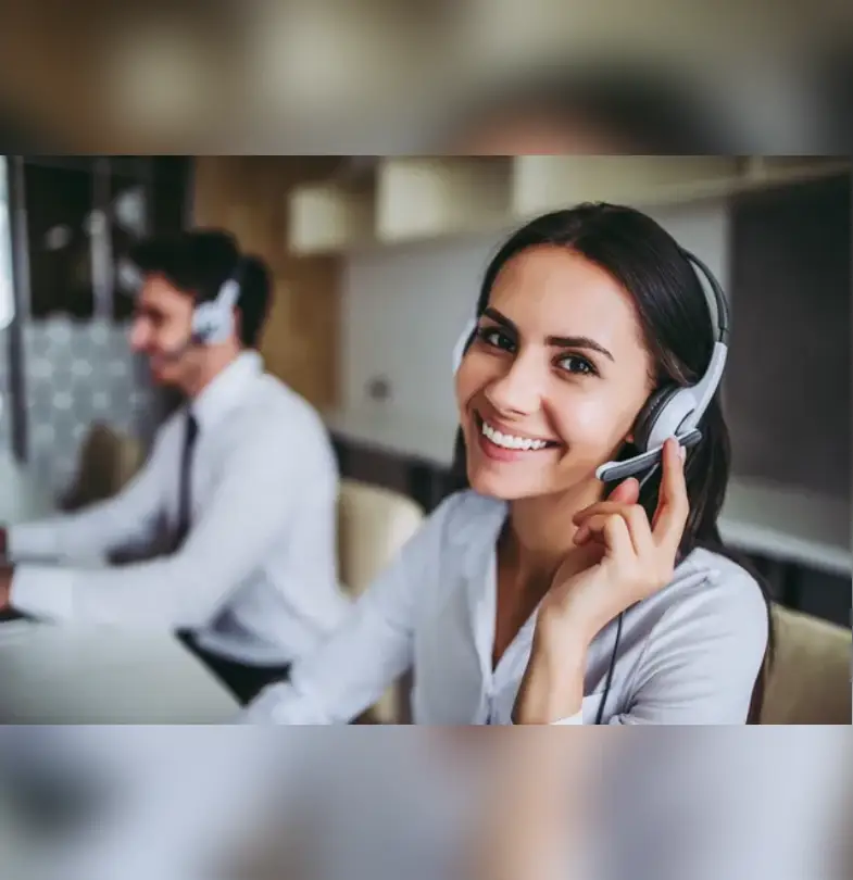 A woman with headphones on sitting in front of another man.